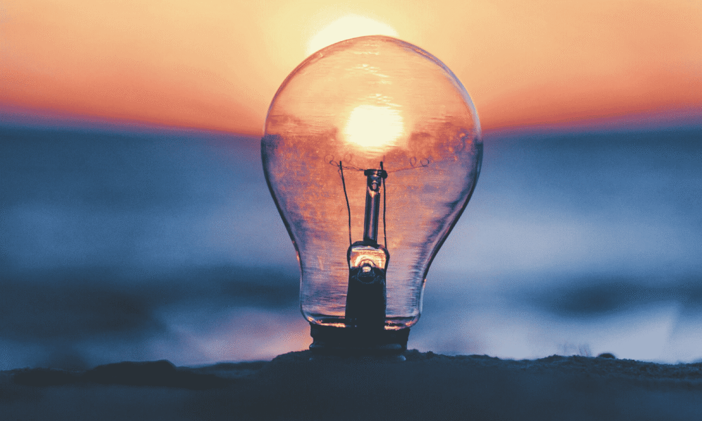 Hehkulamppu, taustalla näkyy auringonlasku.